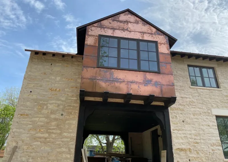Copper metal panel facade on a stone building for Roof Repair in Converse